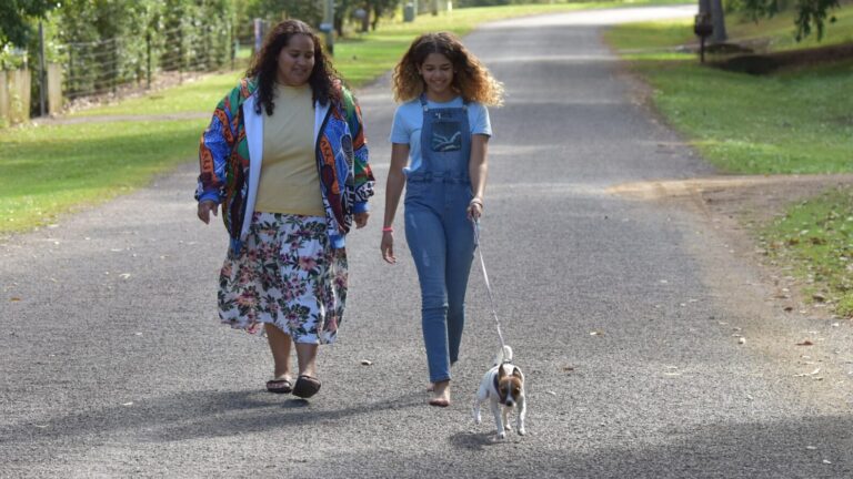 Mother and daughter walk dog