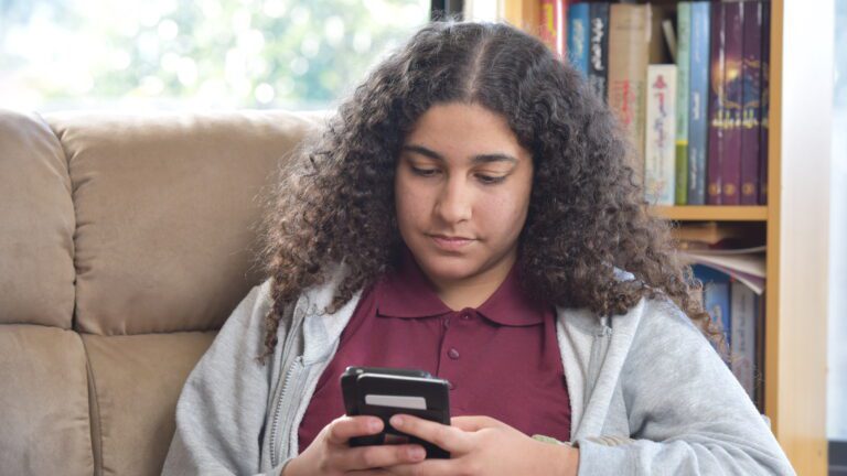 Girl sitting on couch on mobile phone